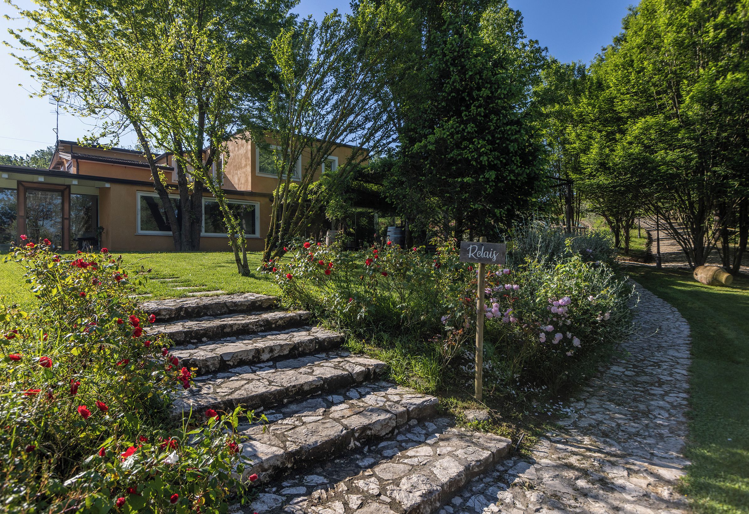Una escalera de piedra conduce a un edificio con jardín.
