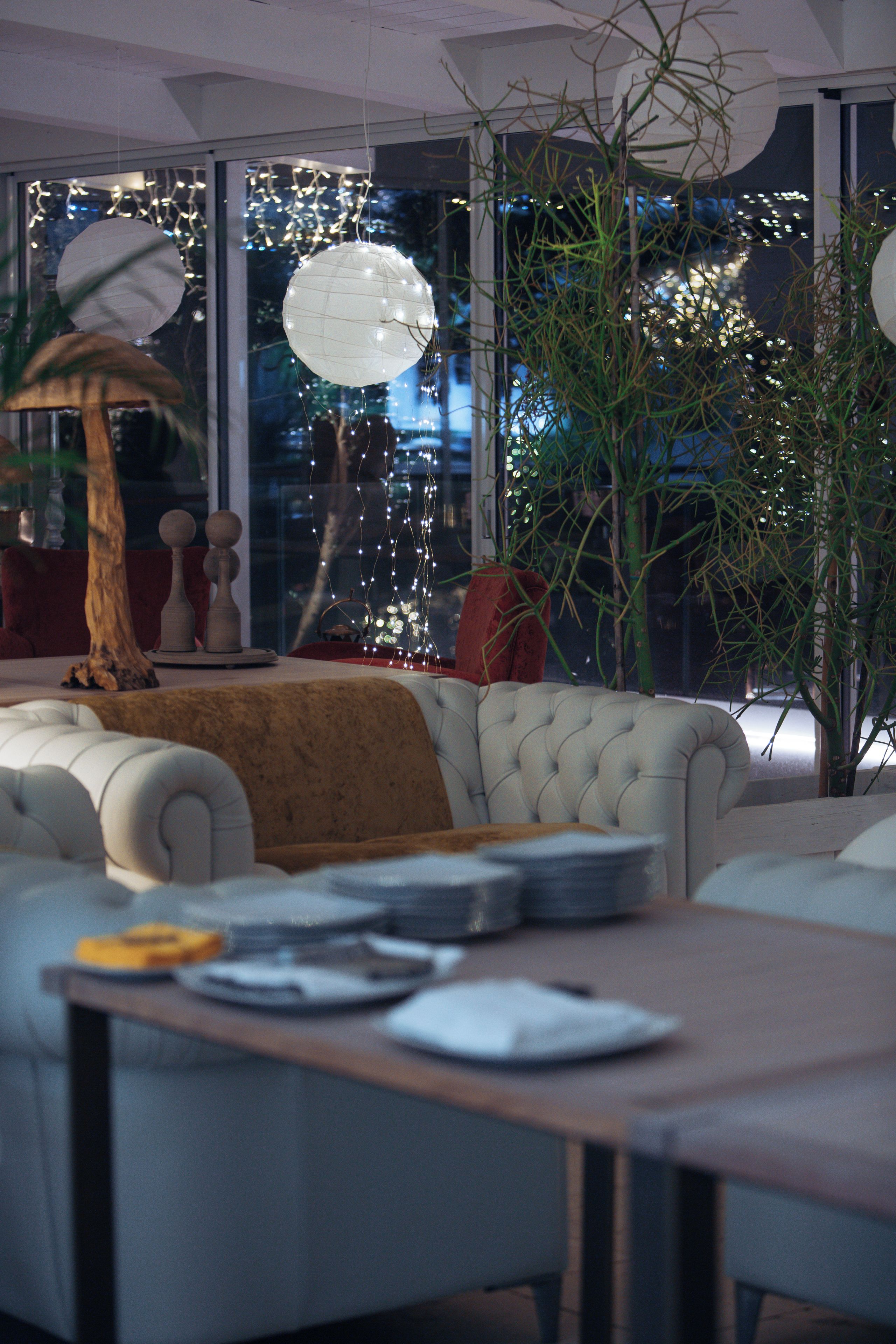 Una sala de estar moderna con un sofá, una mesa de centro y un amplio ventanal con vistas a las luces de la ciudad.