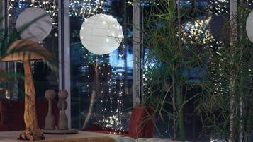 Una sala de estar moderna con un sofá, una mesa de centro y un amplio ventanal con vistas a las luces de la ciudad.