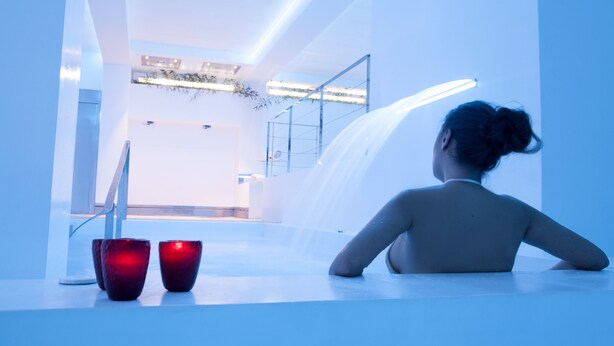 A person sitting by a pool with a view of a modern interior, including a staircase and a railing. - La Pampa Relais & Spa (Melizzano)