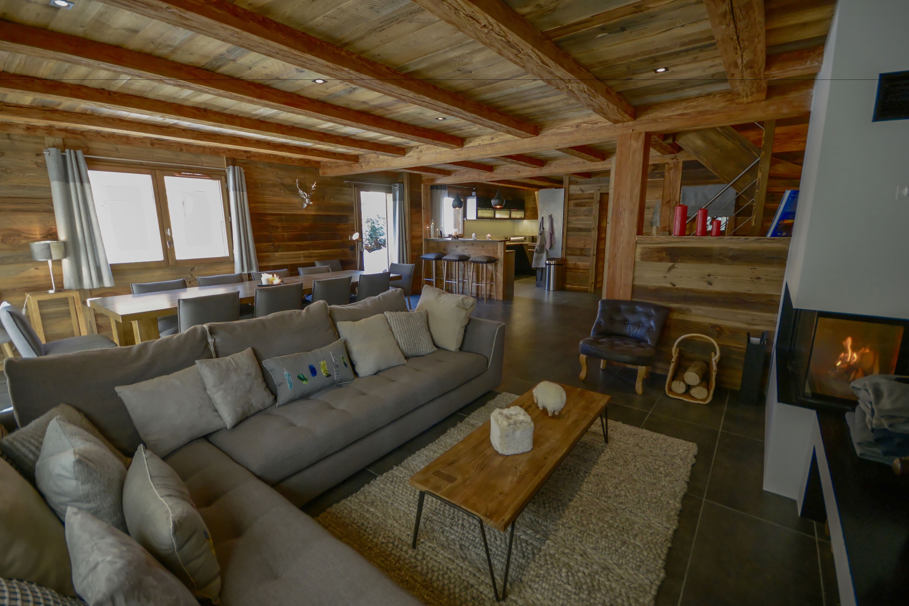 A spacious living room with a large sofa, a wooden coffee table, and a fireplace.