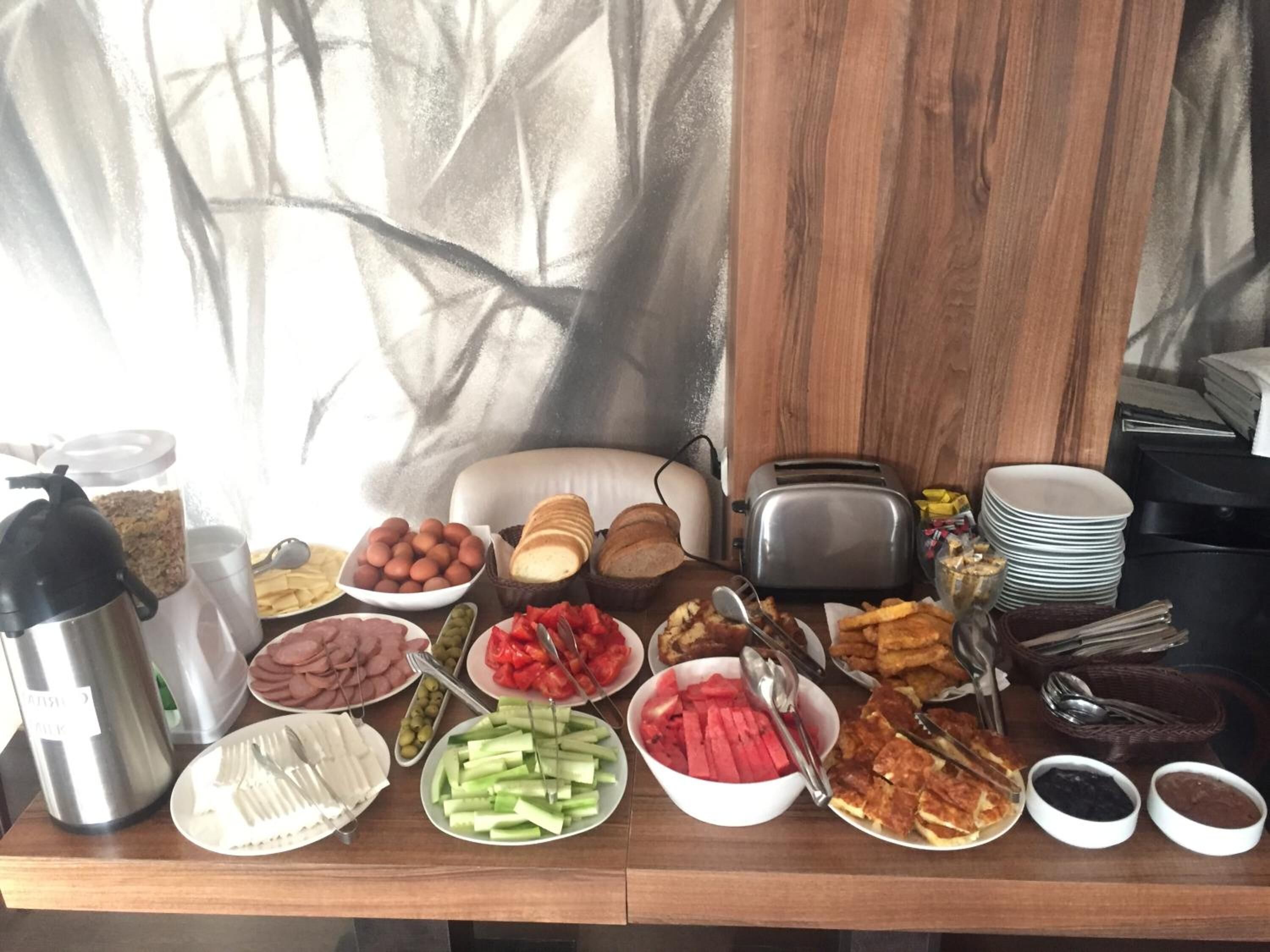 A breakfast buffet with various food items and utensils.