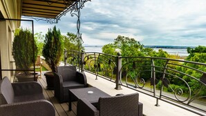 A balcony with wicker furniture and a view of the water. - Hotel Milano (Burgas)