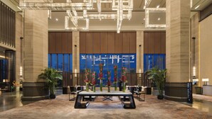 A spacious lobby with a marble floor, a reception desk, and a large digital display on the wall. - Pullman Hefei Sunac (Hefei)
