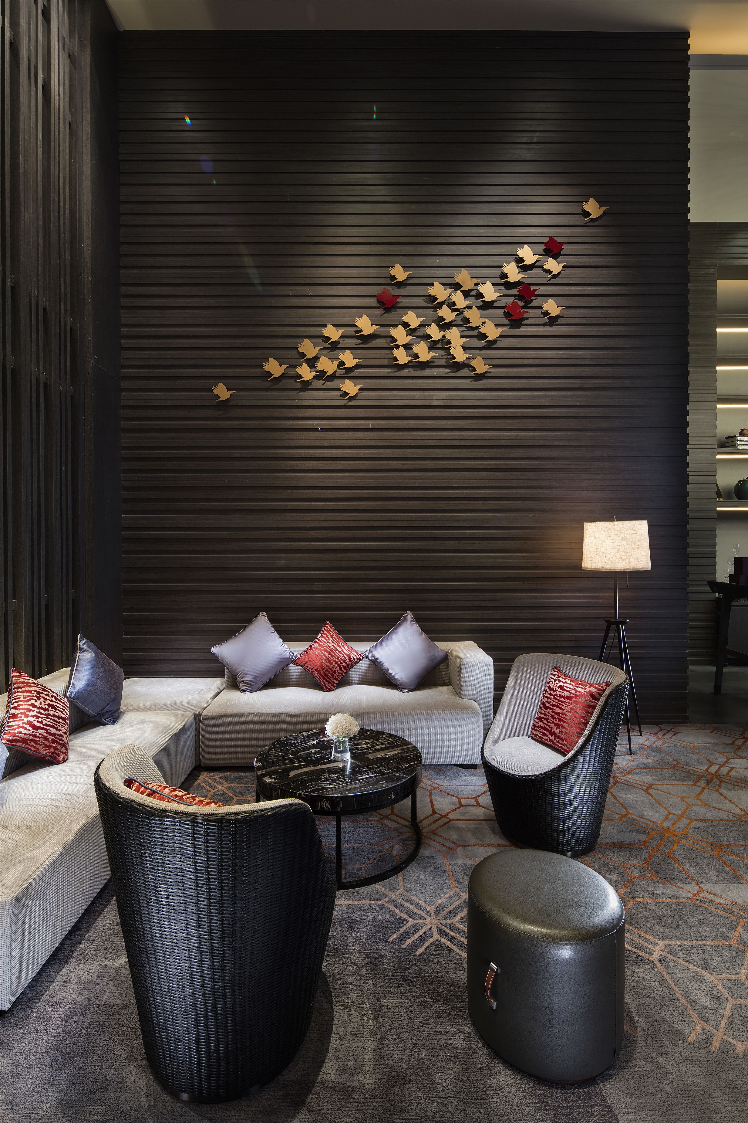 A modern living room with a sectional sofa, two armchairs, a round coffee table, and a floor lamp.