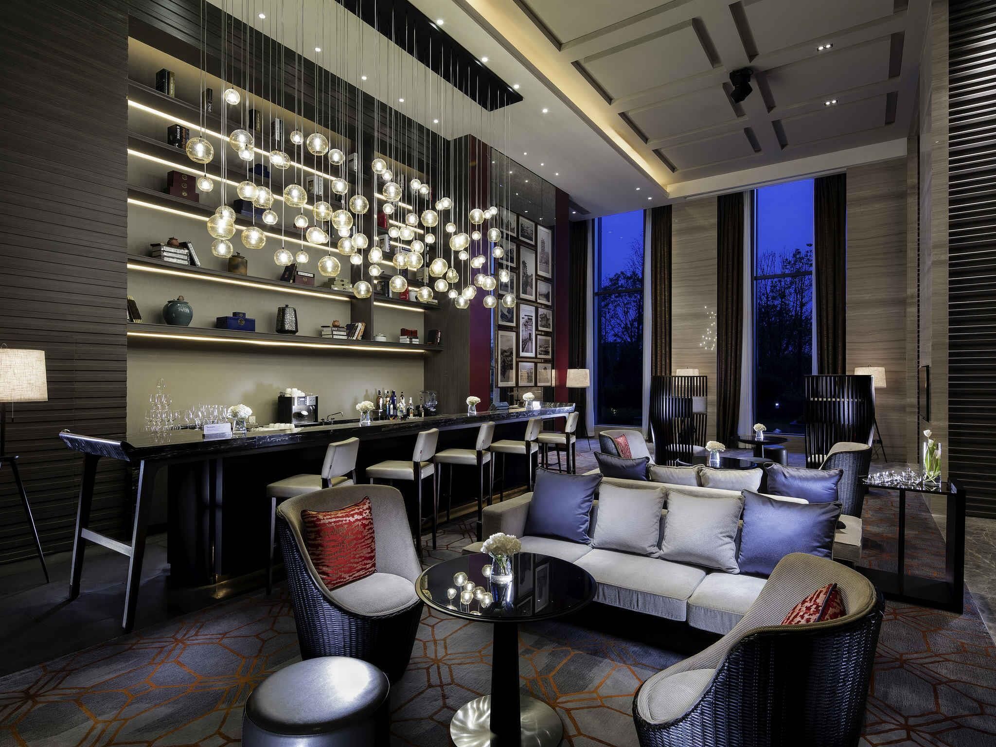 A modern interior with a bar area, seating, and a large window.