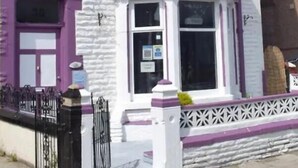 A hotel with a white facade, purple accents, and a sign reading "Orchid Hotel." - Nelcon Hotel (Blackpool)