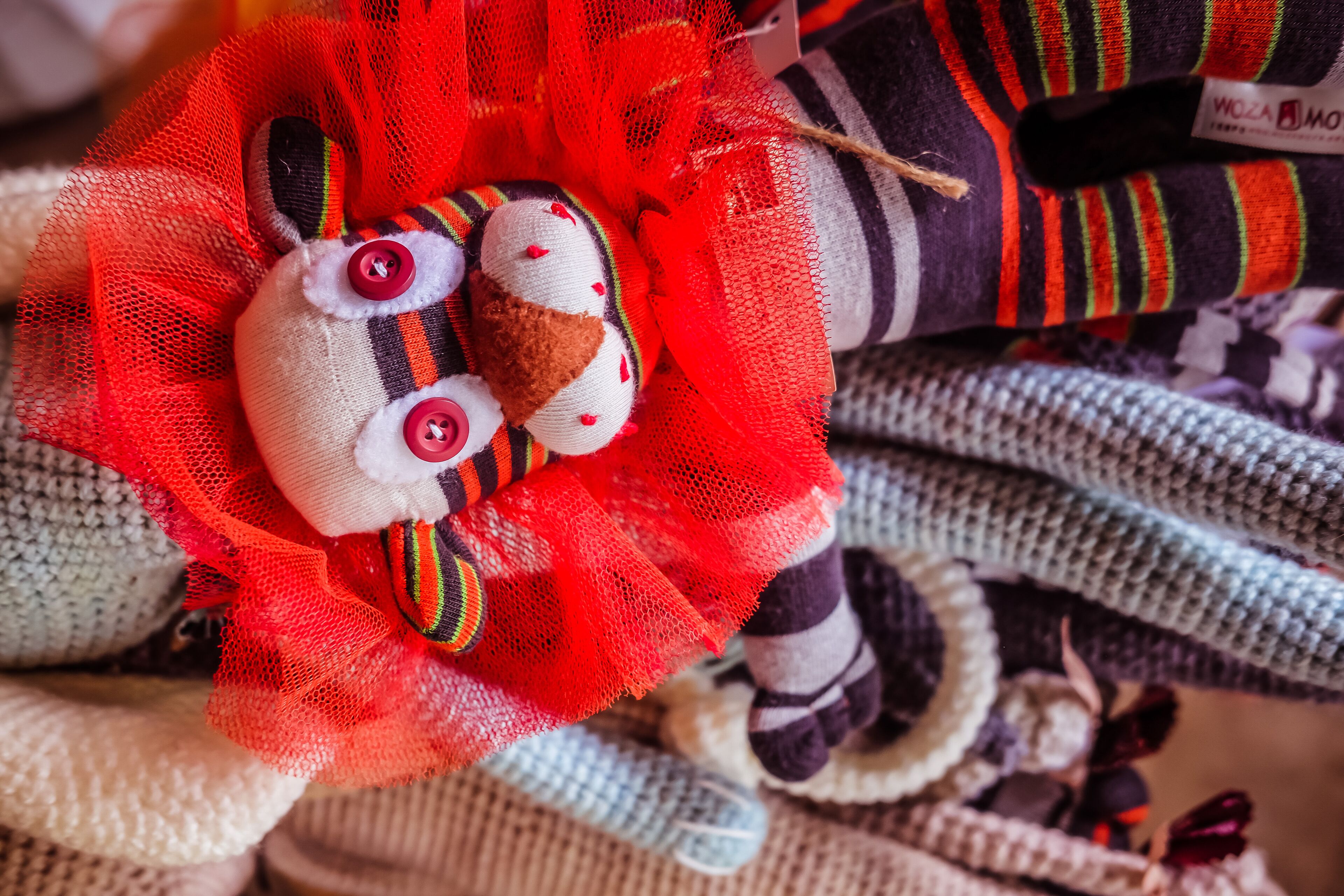 A close-up of a knitted item with a red and white pattern, possibly a part of a larger textile.