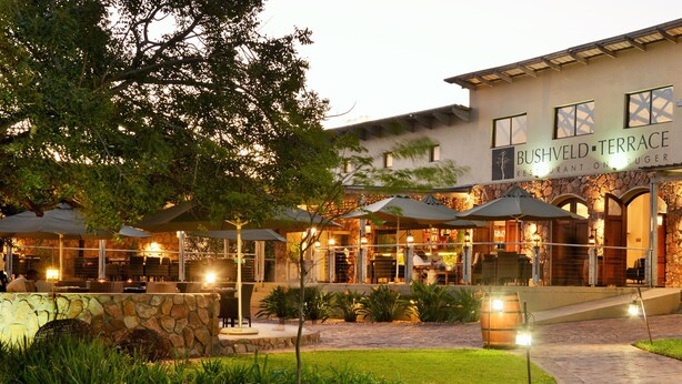Een restaurant met terras, stenen muren en een goed verlichte patio.
