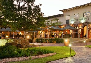 A restaurant with outdoor seating, stone walls, and a well-lit patio area. - Bushveld Terrace Safari Hotel, Lodge & Spa (Phalaborwa)