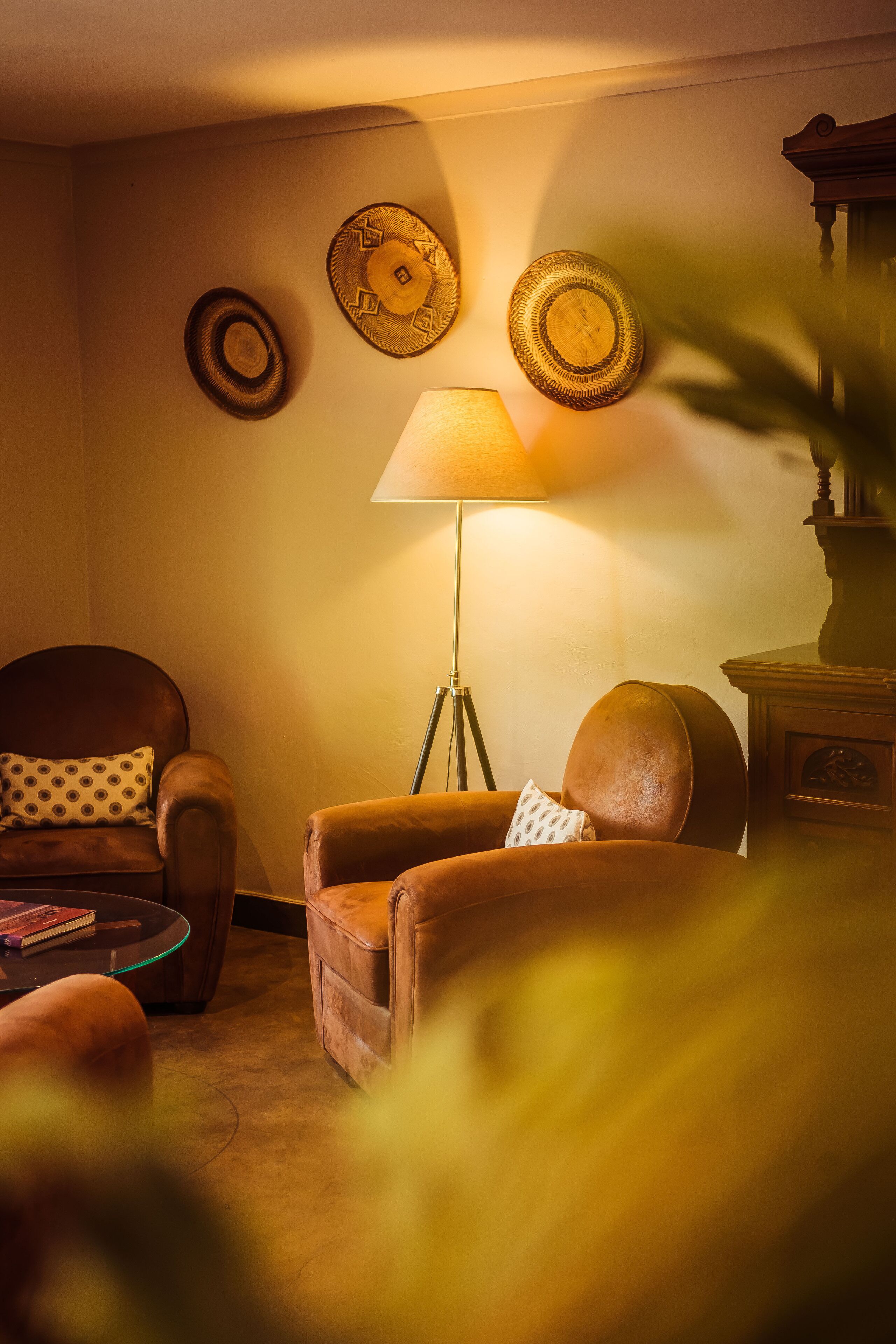 A cozy living room with a brown leather armchair, a small round table, and a floor lamp.