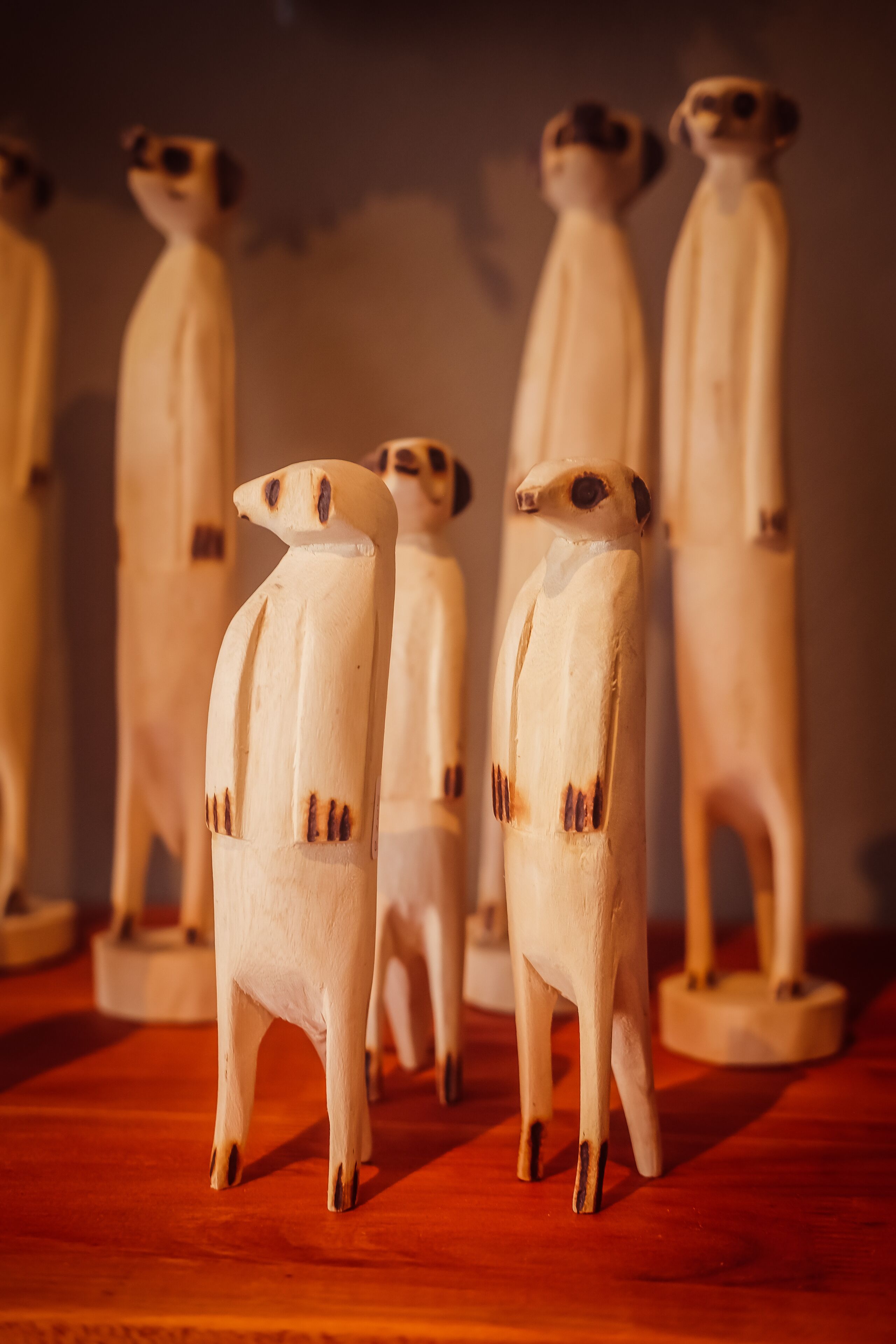 Una colección de esculturas de madera sobre una superficie de madera.