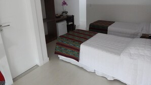 A hotel room with two beds, a desk, a chair, and a small refrigerator. - Gaia Suites Macaé (Macaé)