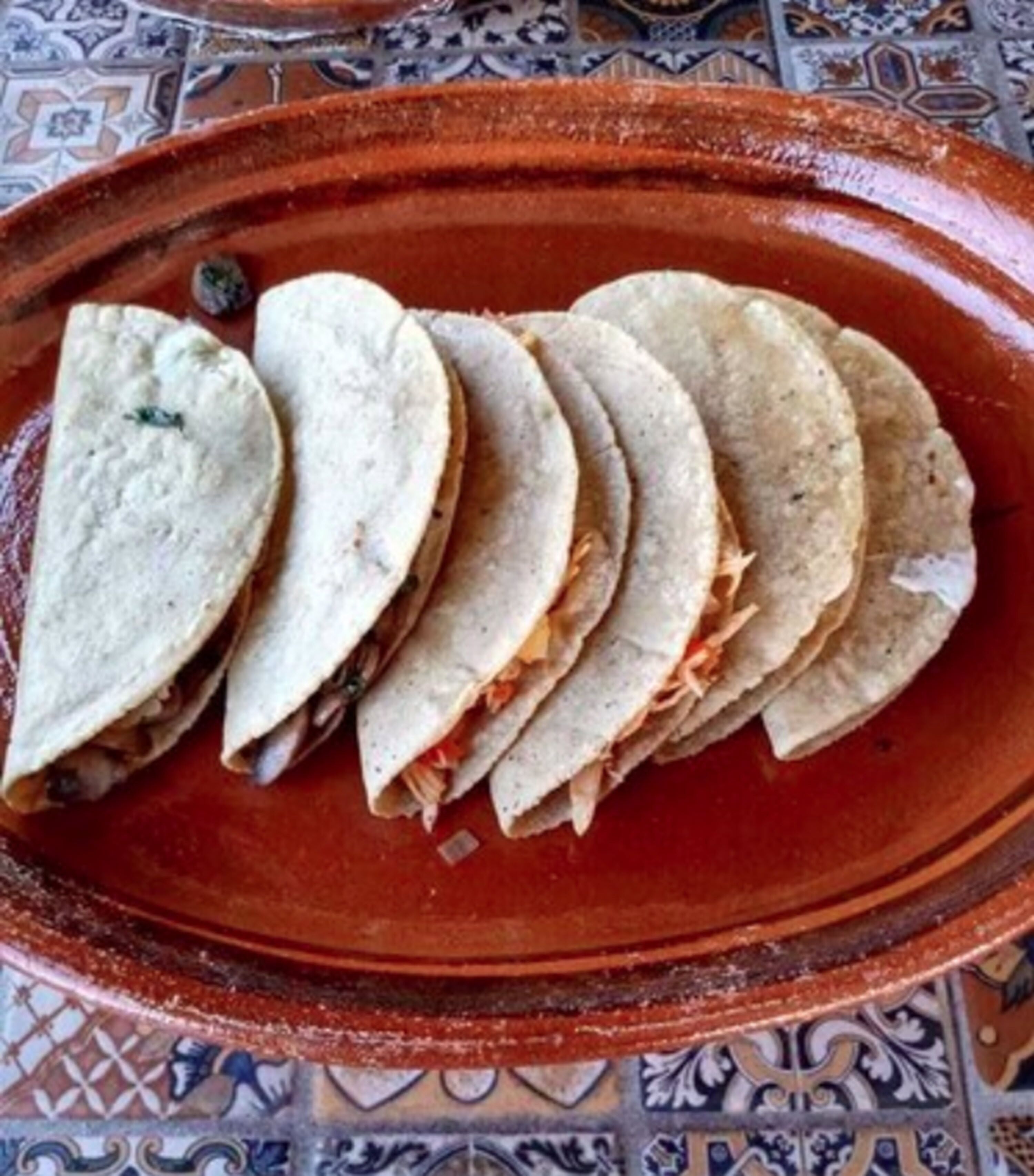 A terracotta plate with several folded tortillas.