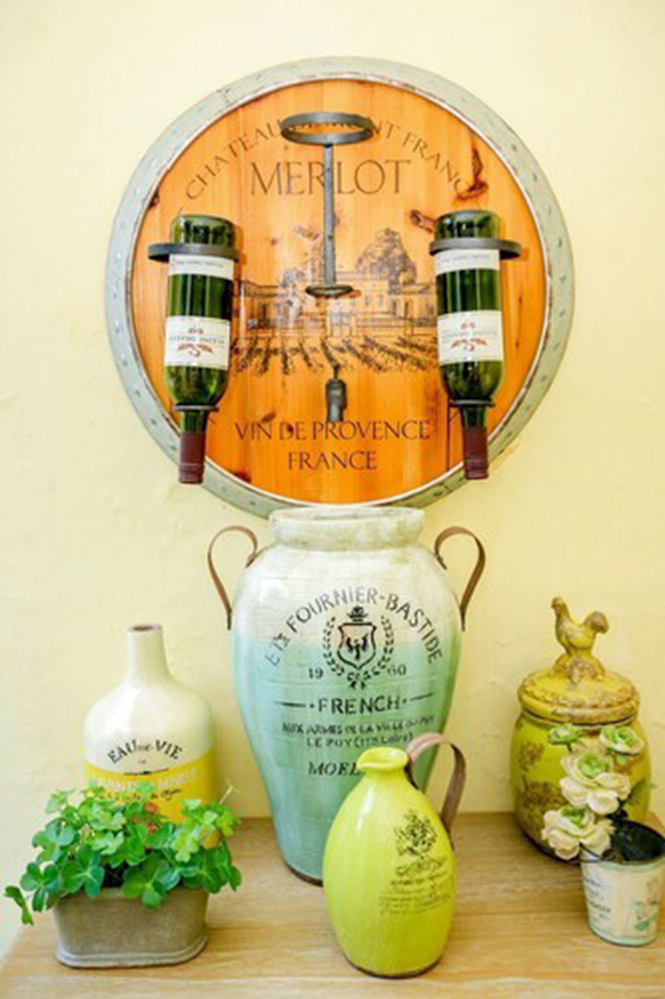 A wine rack with bottles, a large vase, and decorative jars on a shelf.