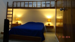A bunk bed room with two bedside tables, each with a lamp. A wooden ladder is attached to the bunk bed. - Casa de Playa Akas (Canoas de Punta Sal)