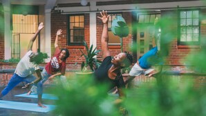 A group of people practicing yoga outdoors.