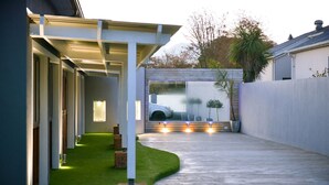 A modern house with a covered patio, a garage, and a well-maintained lawn.