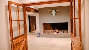 A room with a fireplace, a wooden door frame, and a bull's head decoration above the fireplace.