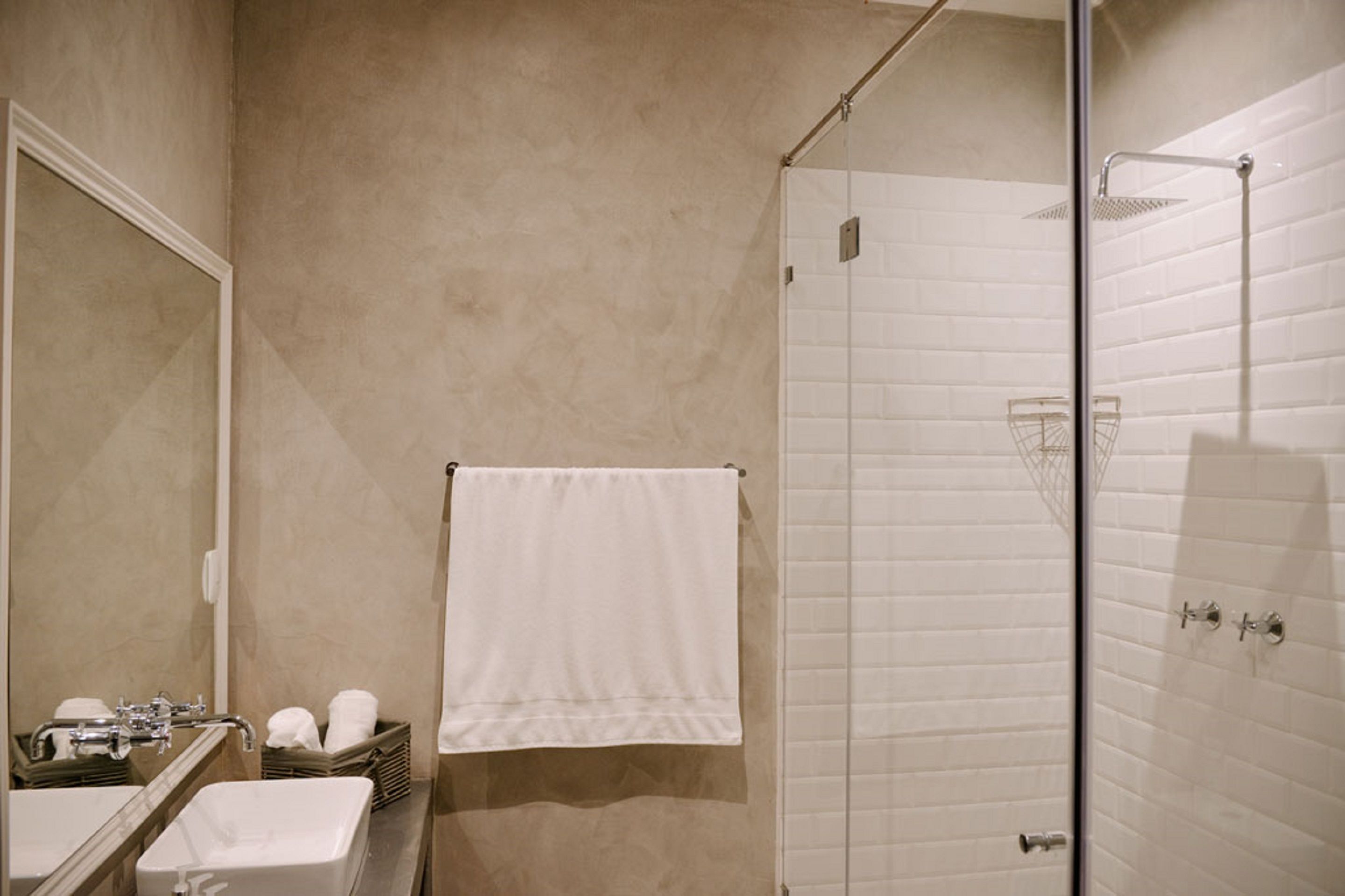 Une salle de bain équipée d’un lavabo, d’un miroir et d’une douche à parois de verre.