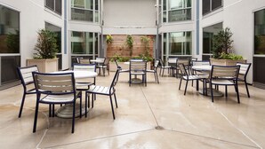 A courtyard with outdoor seating and planters. - Pelican Fully Furnished Apartments (Philadelphia)