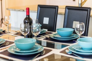 A dining table set with blue plates, bowls, and wine glasses, with a bottle of wine on the table. - Fully Furnished Apartment in Philadelphia (Philadelphia)