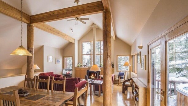 A spacious loft-style room with high ceilings, wooden beams, and large windows offering views of a snowy landscape. - Cool Ridge Town Home at Summerwood 3 Bedroom Holiday home by Key to the Rockies (Dillon)