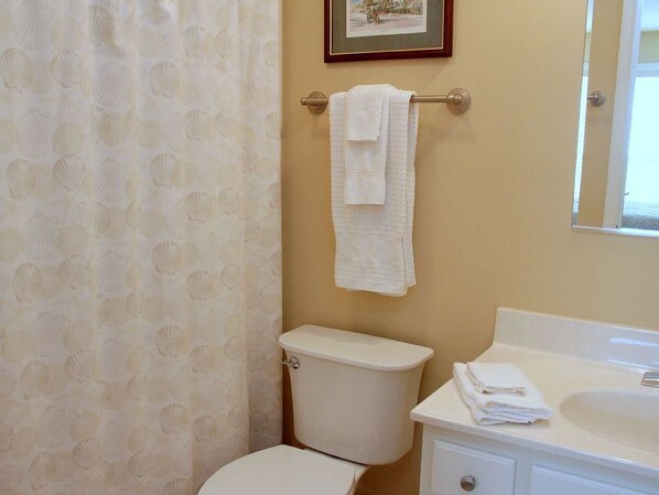 A bathroom with a toilet, sink, and towel rack. - Turtle Bay 10 3 Bedroom Holiday Home By My Ocean Rentals (Folly Beach)