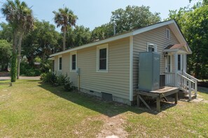 A single-story mobile home with a porch and a utility box.