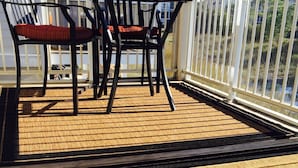 A covered outdoor area with a table and chairs, a laptop, and a glass of water. - Waters Edge 113 Community 3 Bedroom Holiday Home By My Ocean Rentals (Folly Beach)