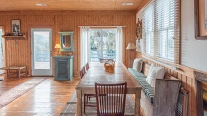 A wooden-paneled room with a dining table, chairs, a bench, and a window with blinds. - E Ashley 1634 4 Bedroom Holiday Home By My Ocean Rentals (Folly Beach)
