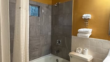 Une salle de bain équipée d’une baignoire, de toilettes et d’un espace douche.