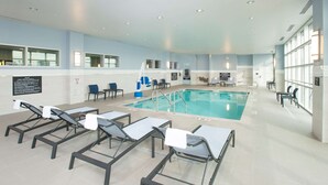 Une piscine intérieure avec des chaises longues et un espace aménagé au bord de la piscine.