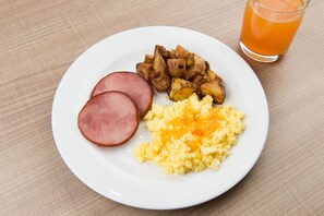 A plate with ham, scrambled eggs, and roasted potatoes. - Homewood Suites by Hilton Concord Charlotte (Concord)