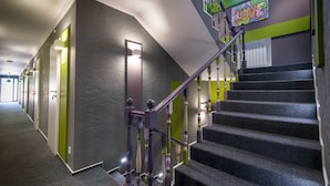 A modern staircase with a green accent wall and a 'LOVE' sign. - Good Night Hotel (Odesa)