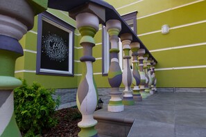 Un edificio con una facciata verde, una serie di ringhiere colorate e un'opera d'arte incorniciata al muro.