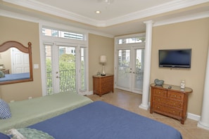 A bedroom with a large bed, a dresser, a television, and a balcony door. - Tuscan Ocean Vista C Holiday Home 8 bedroom By Affordable Large Properties (Myrtle Beach)