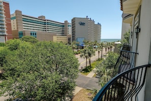 A hotel with multiple floors, a prominent sign, and a view of the ocean.