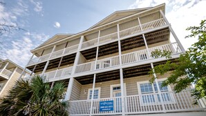 Un edificio de varios pisos con balcones y un cartel que indica que está disponible para alquiler.