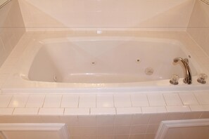 A white freestanding bathtub with a single faucet and a drain. - Bermuda Breeze C Holiday Home 8 bedroom By Affordable Large Properties (North Myrtle Beach)