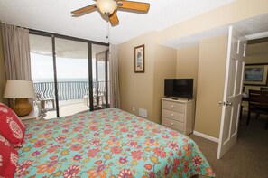 Ein Hotelzimmer mit Bett, Fernseher, Schminktisch und einem Balkon mit Blick.