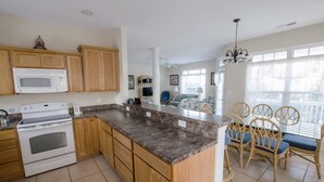 A kitchen with wooden cabinets, a white stove, and a granite countertop.