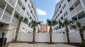 A multi-story hotel with balconies, palm trees, and a central courtyard. - Myrtle Beach 101A Villa 4 bedroom By Affordable Large Properties (Myrtle Beach)