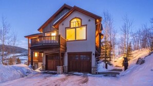 Une maison à deux étages avec un balcon, un garage et une allée.
