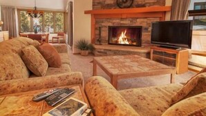 A cozy living room with a fireplace, comfortable seating, and a television. - Pines Condominiums 3 Bedroom Apartment by Key to the Rockies (Keystone)