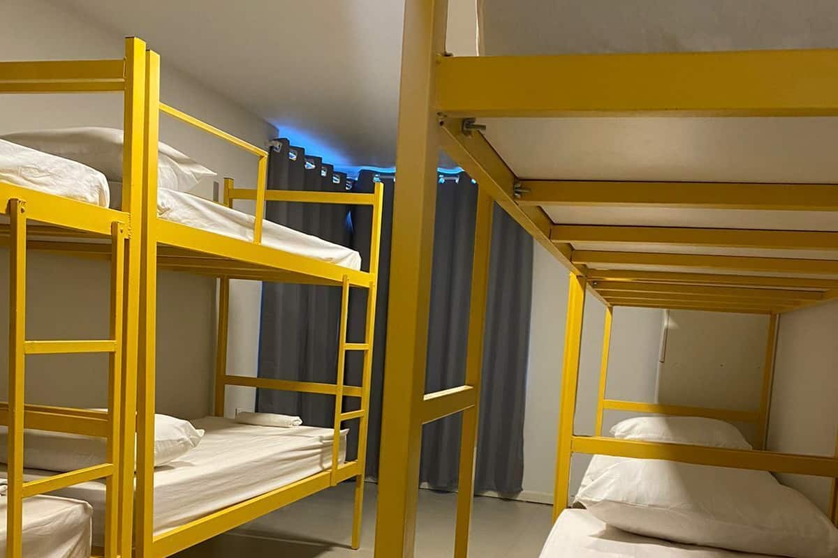 A room with bunk beds, curtains, and a tiled floor.