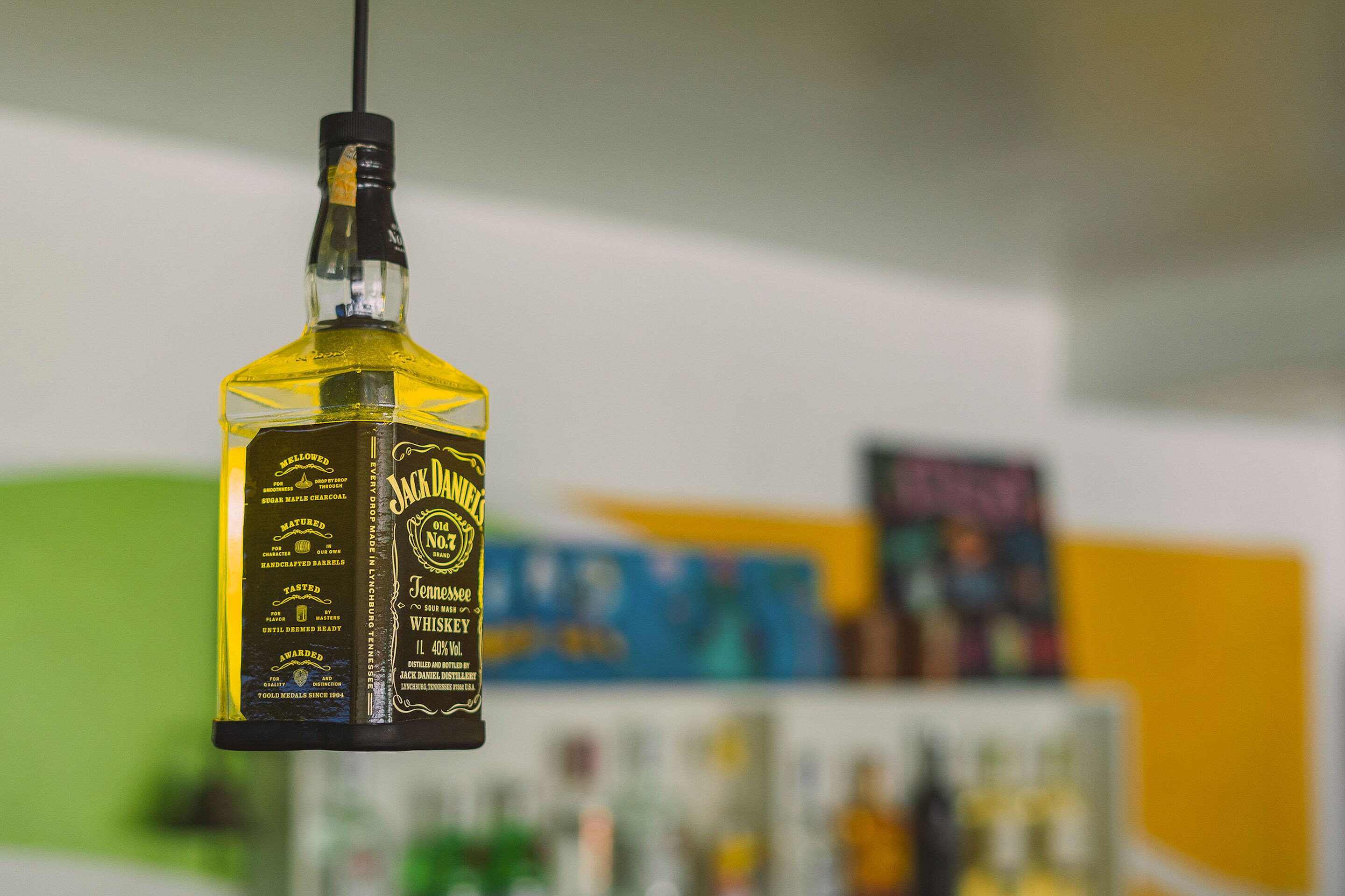 Une bouteille de whisky Jack Daniel's, produit dans le Tennessee, est suspendue à un luminaire fixé au plafond.