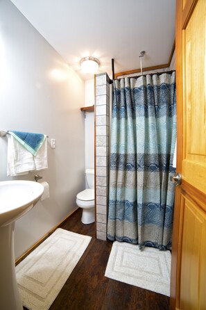 A bathroom with a white sink, a toilet, and a shower curtain.