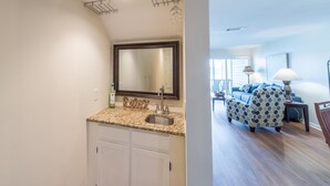 A modern kitchen with granite countertops, a large mirror, and white cabinets. - MARINERS CAY 45 2 Bedroom Holiday Home By My Ocean Rentals (Folly Beach)