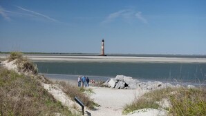 A coastal path leading to a lighthouse with a clear view of the sea. - MARINERS CAY 45 2 Bedroom Holiday Home By My Ocean Rentals (Folly Beach)